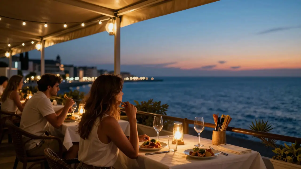 Pareja cenando en una terraza con vistas al mar Mediterráneo al atardecer.